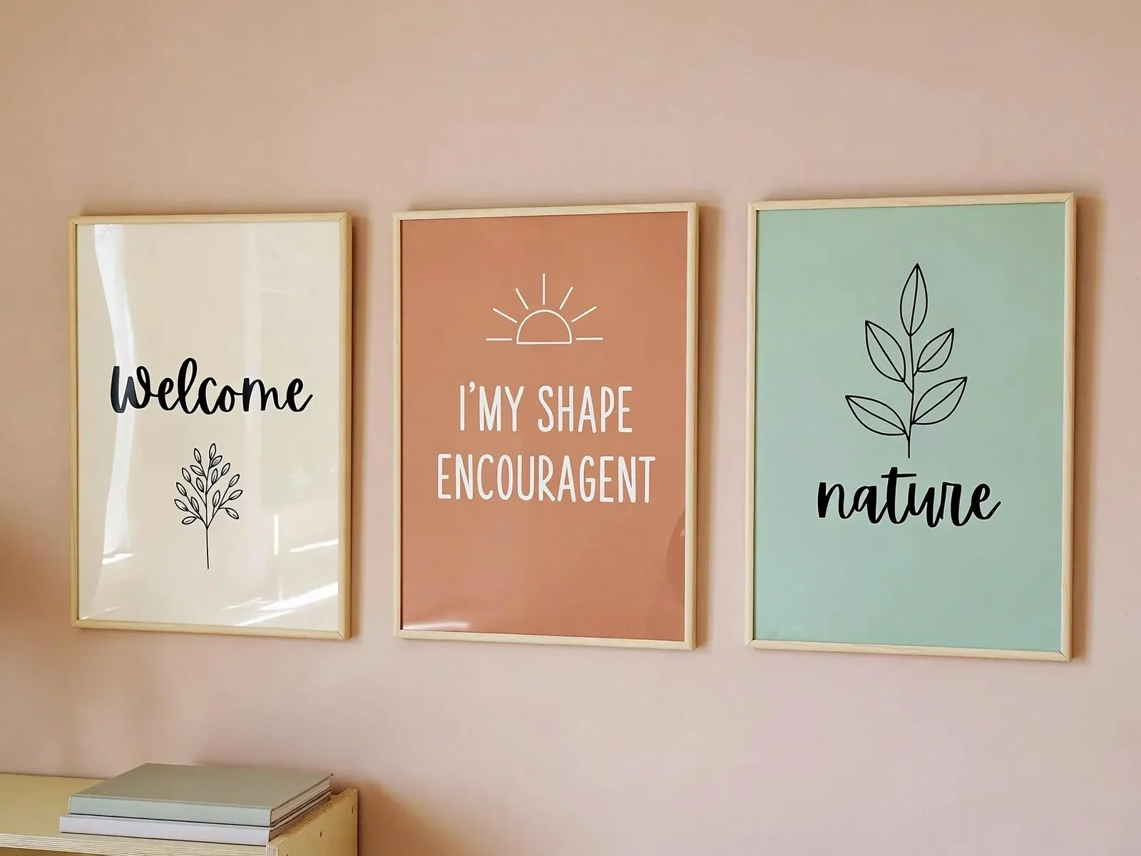 Three framed classroom posters in peach, mint, and cream